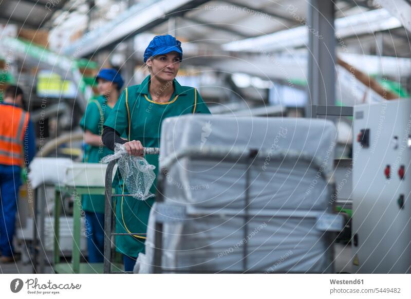 Woman pushing cart in factory woman females women Adults grown-ups grownups adult people persons human being humans human beings industry industrial caucasian