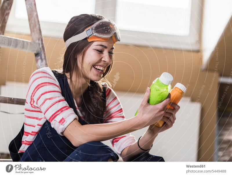 Young woman renovating her new home, holding bottles of paint DIY Doityourself Do it yourself Do-it-yourself young women young woman home ownership