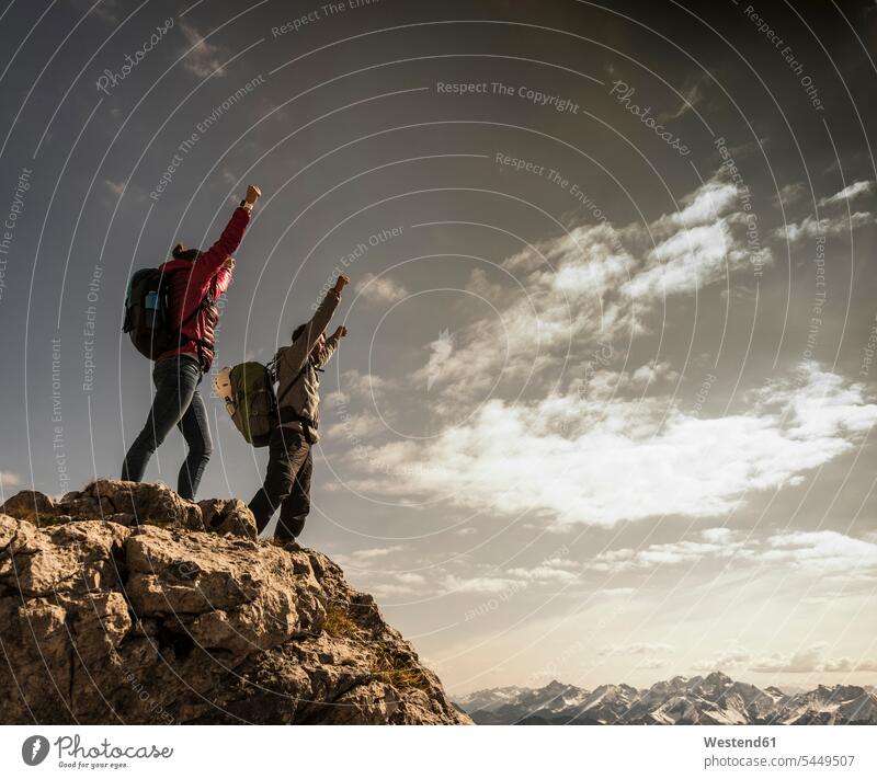Germany, Bavaria, Oberstdorf, two hikers cheering on rock in alpine scenery hiking Travel mountain range mountains mountain ranges summit mountaintops summits