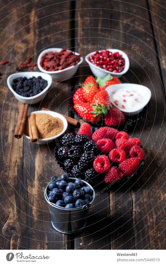 Various dried and fresh fruits and bowl of cinnamon powder with cinnamon sticks on wood food and drink Nutrition Alimentation Food and Drinks pomegranate seed