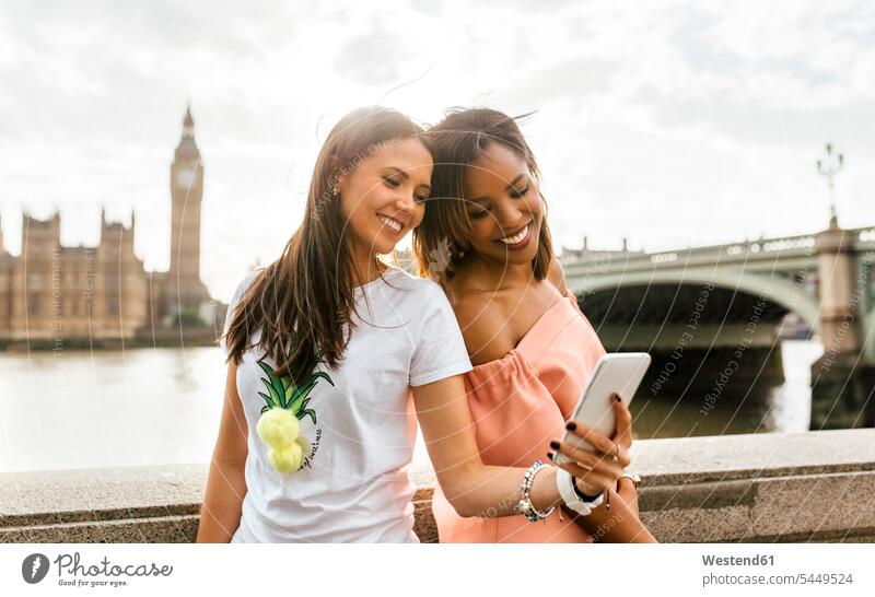 UK, London, two beautiful women taking a selfie near Westminster Bridge female friends Selfie Selfies mobile phone mobiles mobile phones Cellphone cell phone