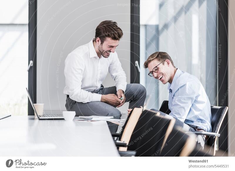 Two laughing colleagues in office Laughter offices office room office rooms Businessman Business man Businessmen Business men Fun having fun funny positive