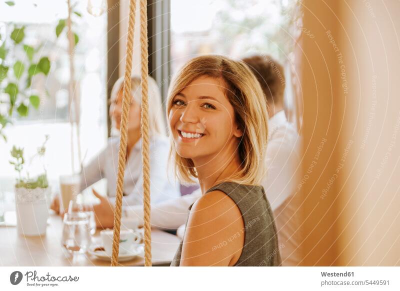 Portrait of smiling young woman in a cafe portrait portraits females women smile Adults grown-ups grownups adult people persons human being humans human beings