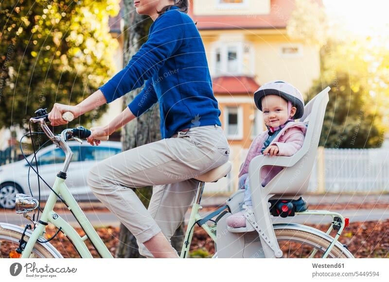 Mother and daughter riding bicycle, baby wearing helmet sitting in children's seat cycling helmet Bike Helmet bicycle helmet bicycle helmets cycling helmets