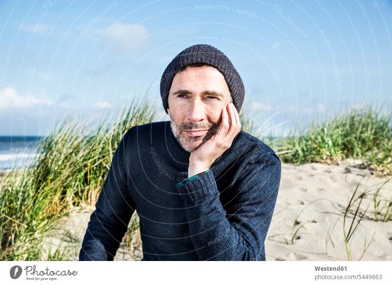 Portrait of man wearing woolly hat on the beach men males portrait portraits relaxed relaxation beaches Adults grown-ups grownups adult people persons