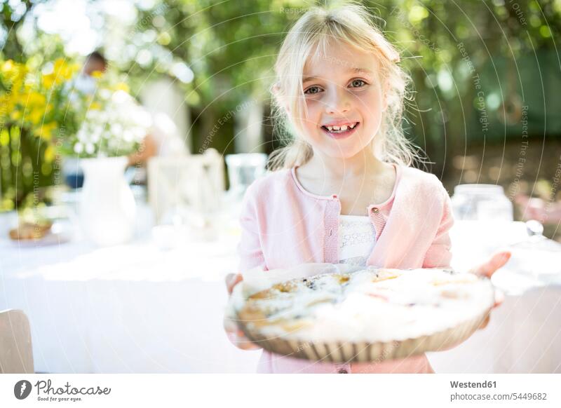 Portrait of smiling girl holding a pie outdoors cake pies cakes females girls smile Sweet Food sweet foods food and drink Nutrition Alimentation Food and Drinks