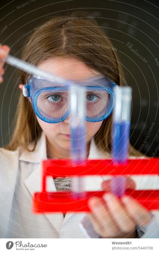 Portrait of girl wearing work coat and safety glasses doing chemical experiment portrait portraits experimenting females girls attempt child children kid kids