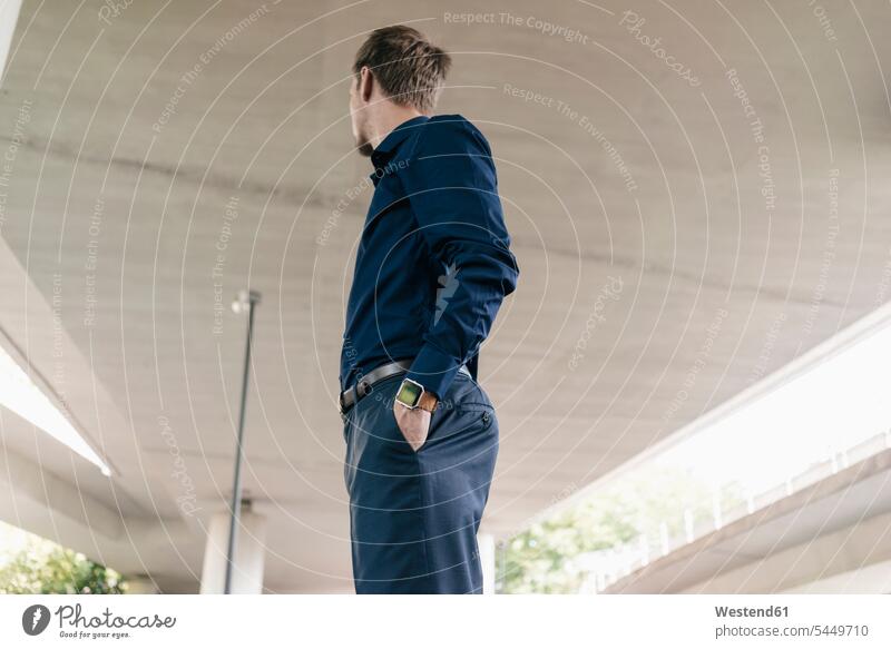 Businessman standing at underpass looking around Business man Businessmen Business men business people businesspeople business world business life males Germany