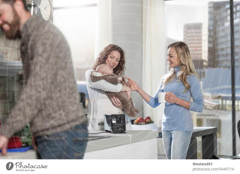 Mother and friend with baby in kitchen cooking smiling smile domestic kitchen kitchens family families mother mommy mothers ma mummy mama people persons