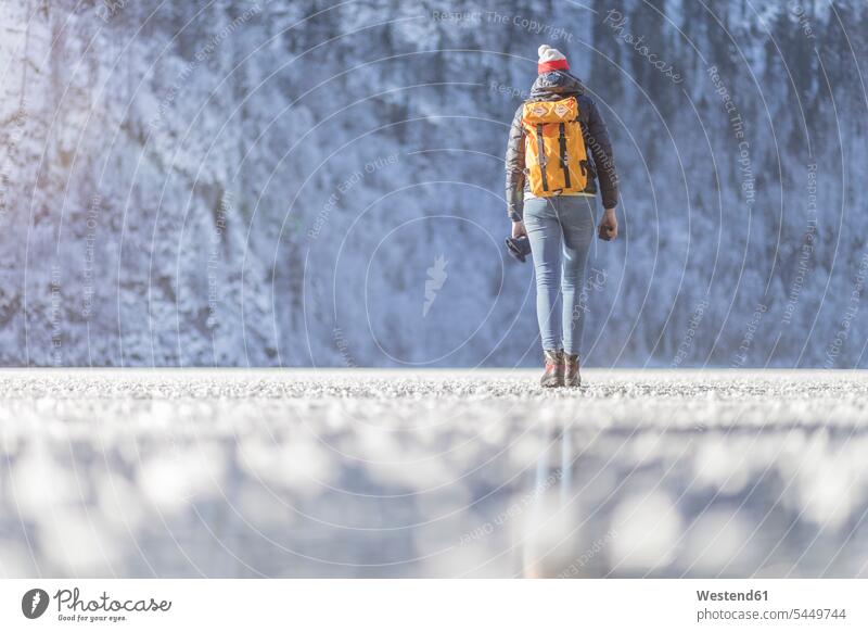Germany, Berchtesgadener Land, back view of woman with backpack walking on frozen Lake Koenigssee winter hibernal females women Adults grown-ups grownups adult
