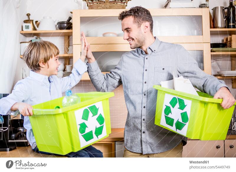 Father and son at home with waste boxes family families recycling ecology recycle sons manchild manchildren smiling smile father pa fathers daddy dads papa