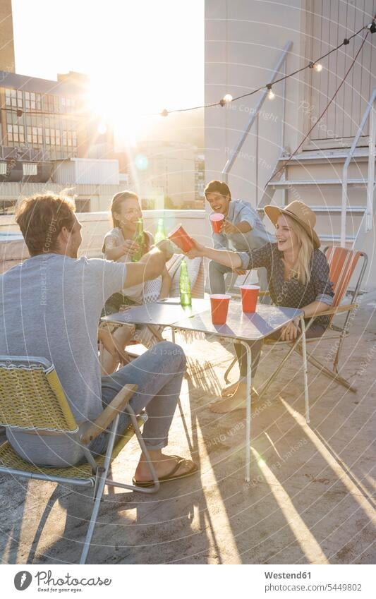 Friends having a rooftop party on a beautiful summer evening together roof terrace deck enjoying indulgence enjoyment savoring indulging friends summer time