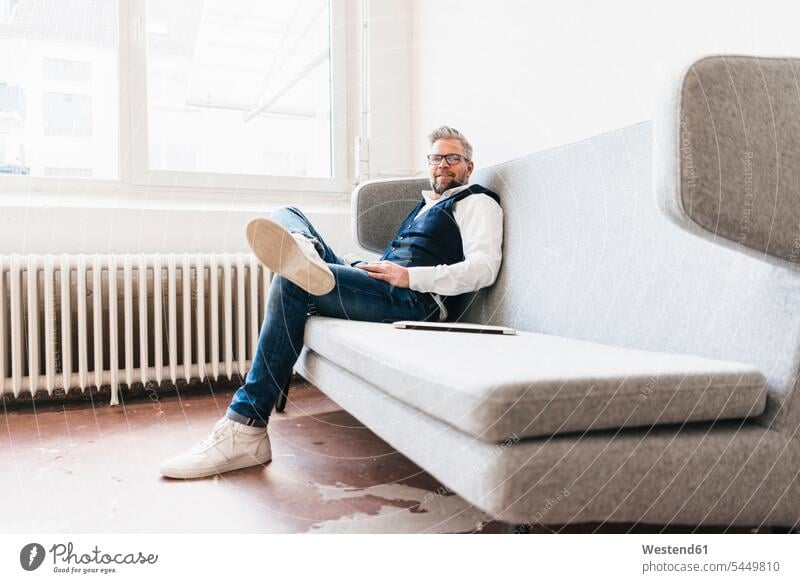 Businessman with laptop, relaxing on coach Office Offices Business man Businessmen Business men business people businesspeople business world business life