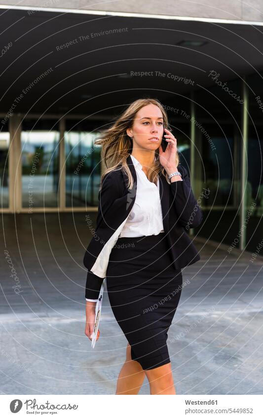 Walking businesswoman on the phone businesswomen business woman business women walking going call telephoning On The Telephone calling business people