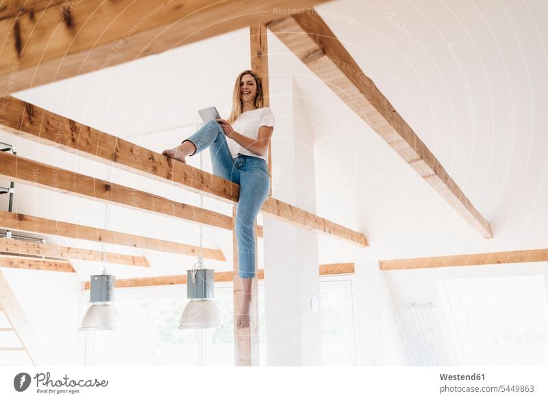 Carefree young woman sitting on ceiling joist ceiling joists tablet digitizer Tablet Computer Tablet PC Tablet Computers iPad Digital Tablet digital tablets