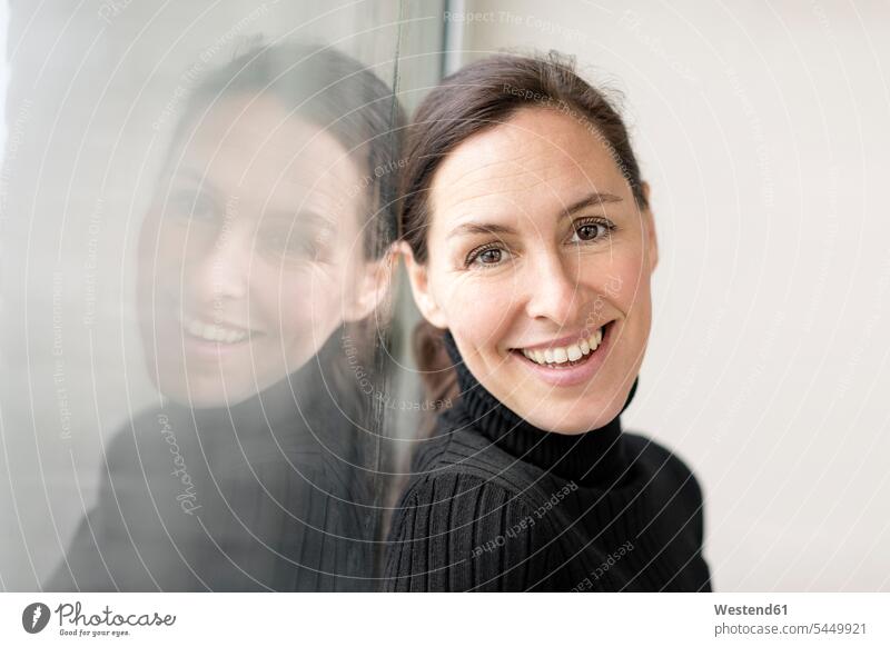 Reflection and portrait of smiling businesswoman wearing black turtleneck pullover females women portraits Adults grown-ups grownups adult people persons