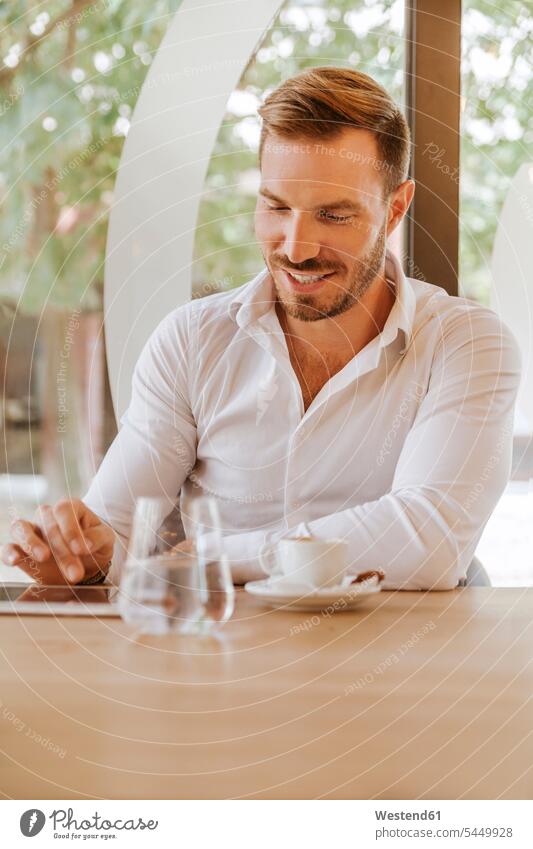 Smiling man with tablet in a cafe Businessman Business man Businessmen Business men males digitizer Tablet Computer Tablet PC Tablet Computers iPad