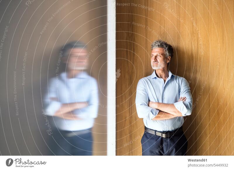 Reflection of mature businessman standing at wooden wall wooden walls Businessman Business man Businessmen Business men reflection reflexion Reflecting