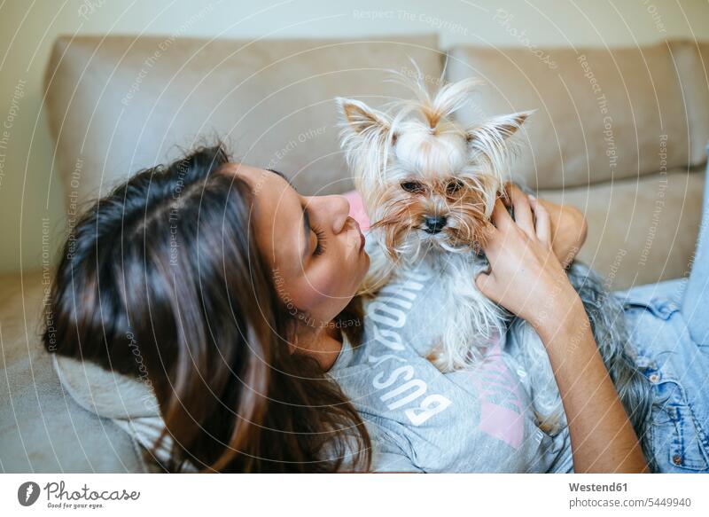 Woman lying on couch with her Yorkshire Terrier dog dogs Canine woman females women pets animal creatures animals Adults grown-ups grownups adult people persons