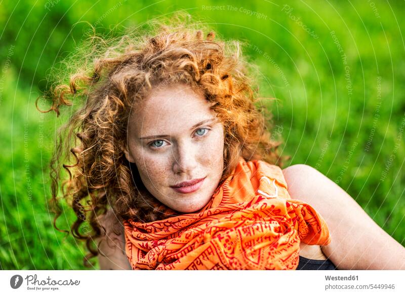 Portrait of freckled young woman with curly red hair wearing orange scarf portrait portraits females women Adults grown-ups grownups adult people persons
