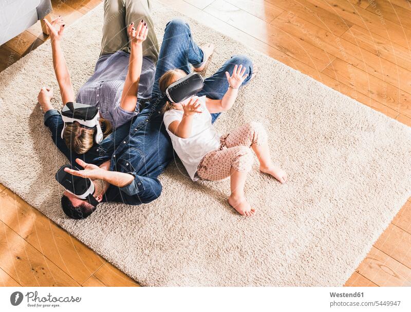 Family using VR goggles at home carpet carpets rug rugs digitization digitazing digitalisation digitalization interactive interactivity wearable