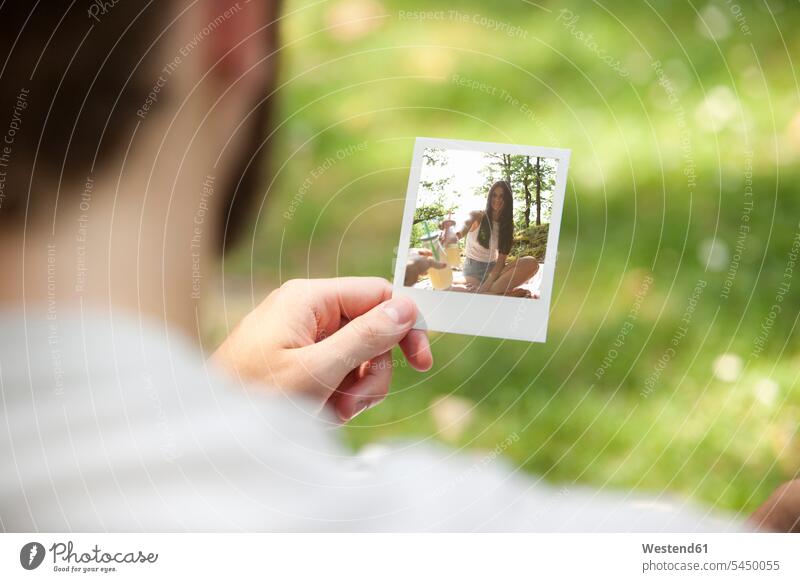 Man holding instant photo of his girlfriend, partial view photograph photographs photos hand human hand hands human hands image images picture pictures people