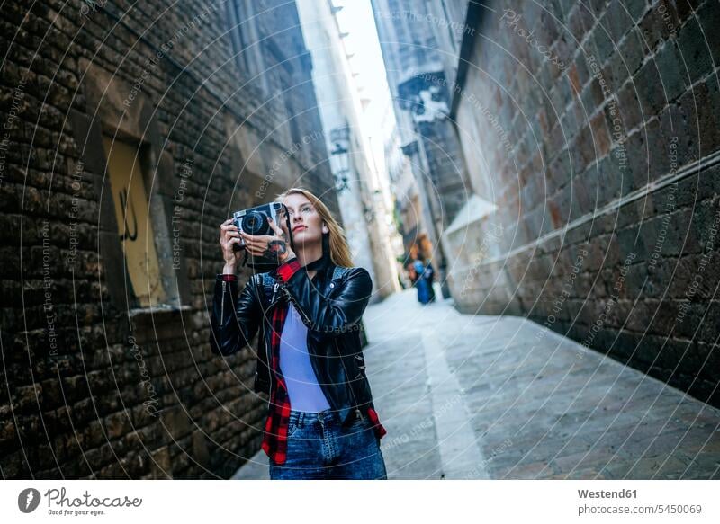 Spain, Barcelona, young woman taking pictures with reflex camera at Gothic Quarter photographing cameras females women Adults grown-ups grownups adult people