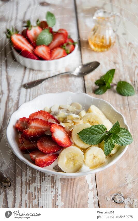Bowl of porridge with strawberries and banana Breakfast Porridge culinary herb culinary herbs Mint Mentha Mints mint leaf mint leaves Strawberry Strawberries