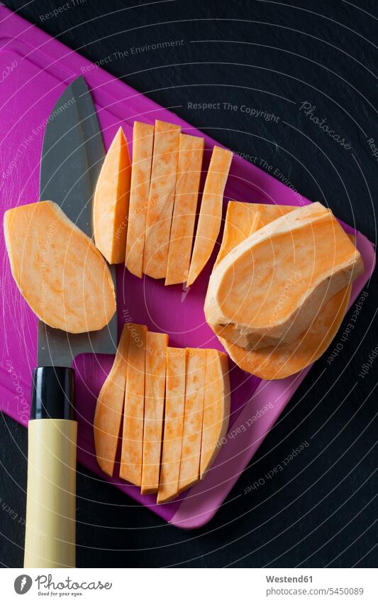 Sliced and sweet potato on chopping board food and drink Nutrition Alimentation Food and Drinks dark background French Fries french fry Kitchen Knife