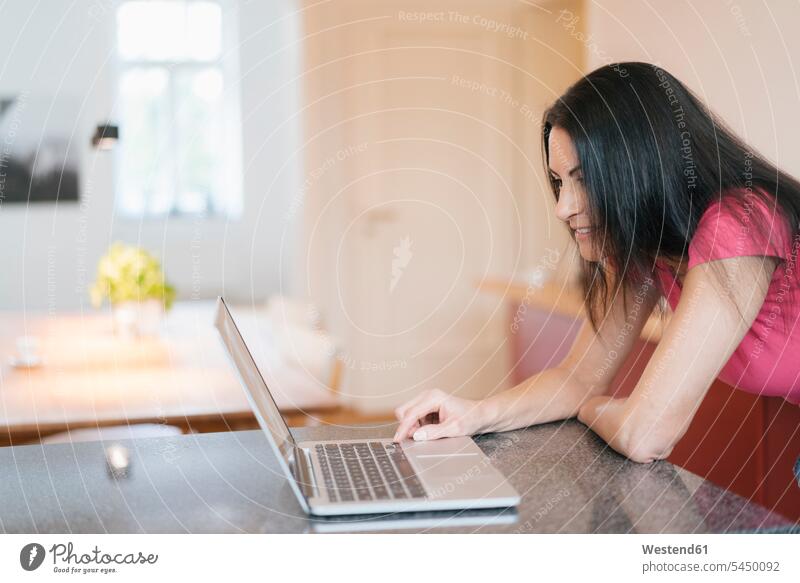 Woman using laptop at home Laptop Computers laptops notebook woman females women computer computers Adults grown-ups grownups adult people persons human being