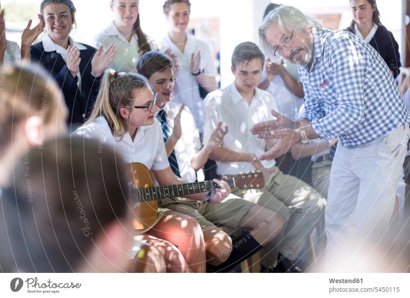 Teacher and students having music lessons outside teacher instructor teachers clapping hands applauding applause Clapping clap hands pupils pedagogue pedagogues