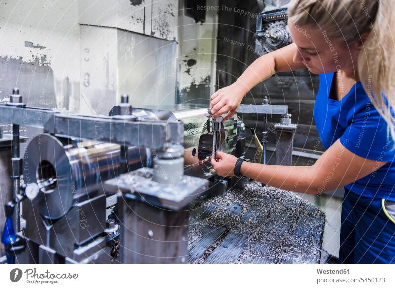 Woman working on machine in industrial factory woman females women factories At Work Adults grown-ups grownups adult people persons human being humans