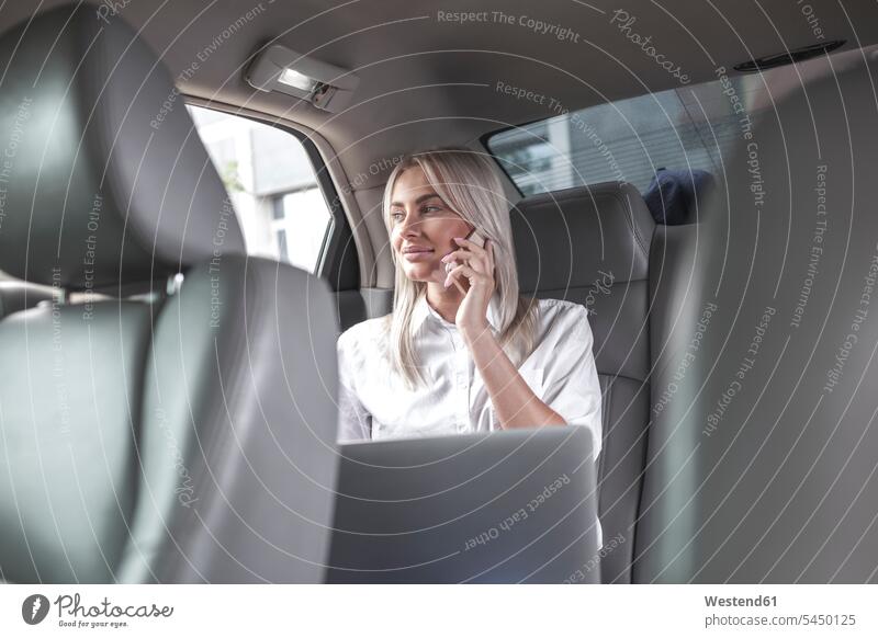 Smiling businesswoman on cell phone in car businesswomen business woman business women females on the phone call telephoning On The Telephone calling smiling