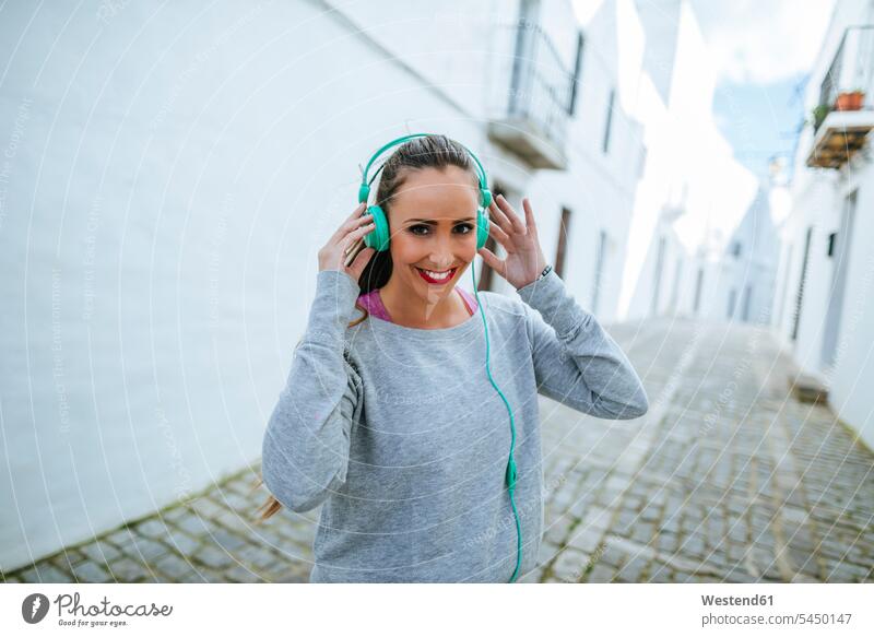 Young woman wearing headphones for workout females women young Listening Music headset Adults grown-ups grownups adult people persons human being humans
