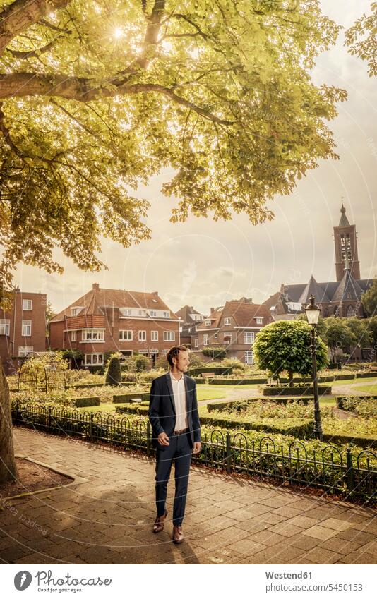 Netherlands, Venlo, businessman standing on pavement Businessman Business man Businessmen Business men city town cities towns business people businesspeople