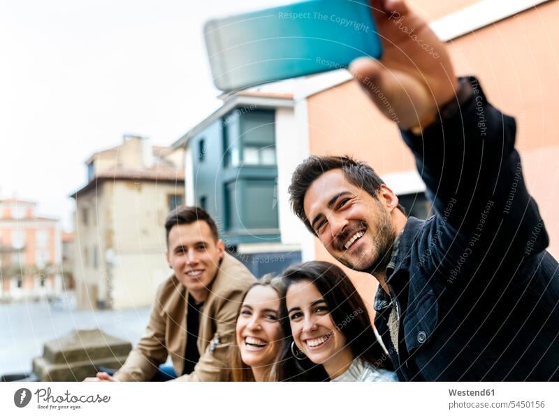 Group of friends taking a selfie in the city mobile phone mobiles mobile phones Cellphone cell phone cell phones Selfie Selfies friendship telephones