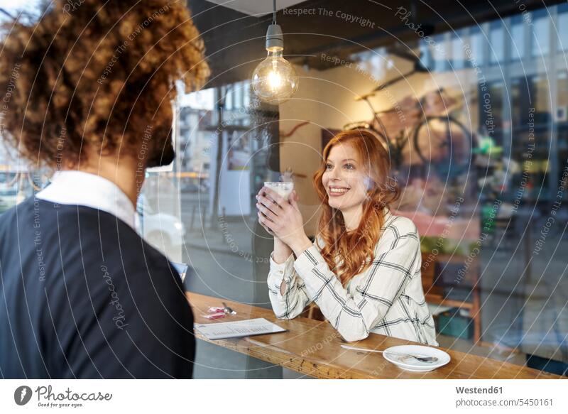 Man looking at smiling young woman in a cafe couple twosomes partnership couples smile window windows people persons human being humans human beings appointment
