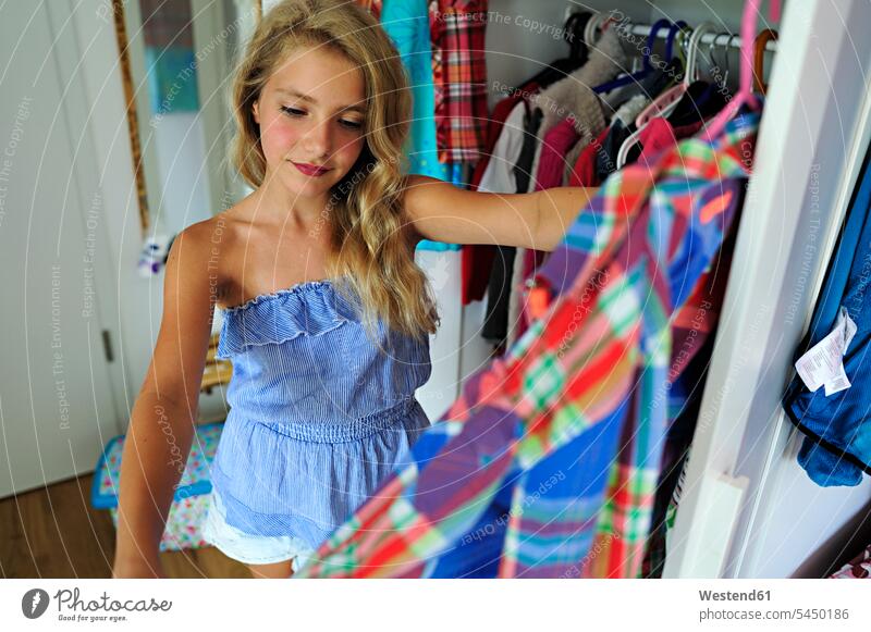 Girl choosing clothes from wardrobe girl females girls looking view seeing viewing clothing choose child children kid kids people persons human being humans