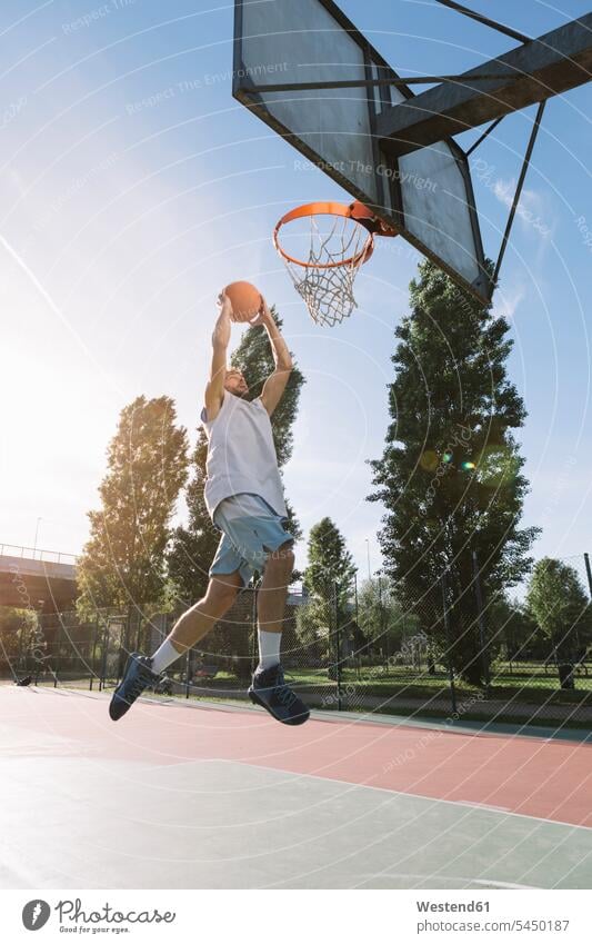Man playing basketball basketballs jumping Leaping leisure free time leisure time sport sports man men males basketball player basketball players throwing
