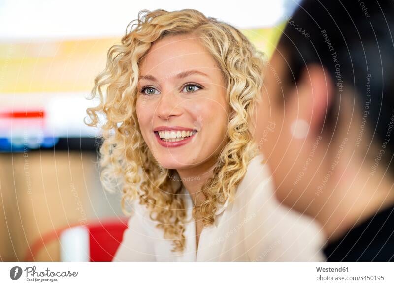 Blond businesswoman listening to presentation females women casual sitting Seated teamwork teamworking qualification further education continuing education