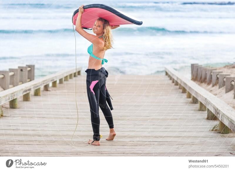 Woman walking to beach with surfboard surfboards surfing surf ride surf riding Surfboarding beaches going carrying woman females women water sports Water Sport