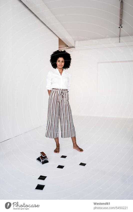 Young woman standing with instant camera and film on the floor instant film polaroid film instant print film instant photo instant photography polaroids