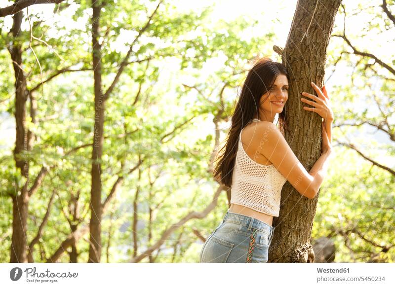 Young woman in forest hugging a tree Tree Trees embracing embrace Embracement smiling smile females women Adults grown-ups grownups adult people persons