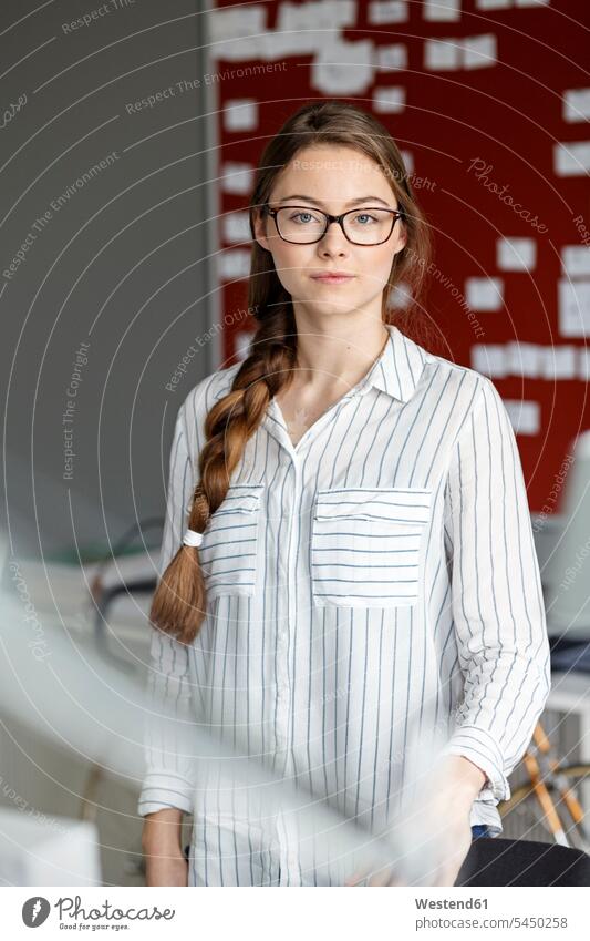Portait of confident young woman in office in front of scrum board portrait portraits offices office room office rooms serious earnest Seriousness austere