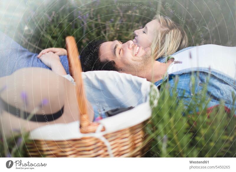 Young couple lying in lavender field twosomes partnership couples smiling smile relaxed relaxation people persons human being humans human beings relaxing Field