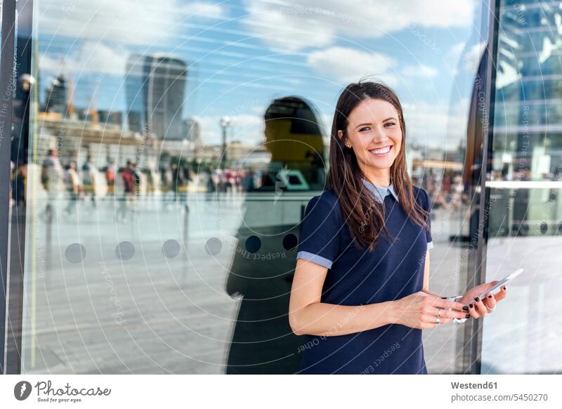UK, London, portrait of smiling woman with smartphone in the city females women mobile phone mobiles mobile phones Cellphone cell phone cell phones smile Adults