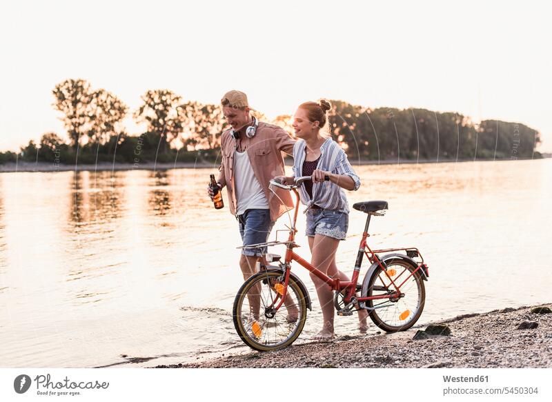 Young couple with bicycle wading in river smiling smile walking going twosomes partnership couples people persons human being humans human beings River Rivers
