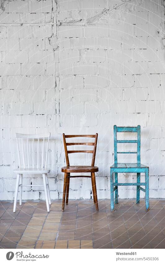 Empty chairs against white brick wall loft lofts walls copy space nobody variation various different three objects 3 in a row Rows divers Variety diversity