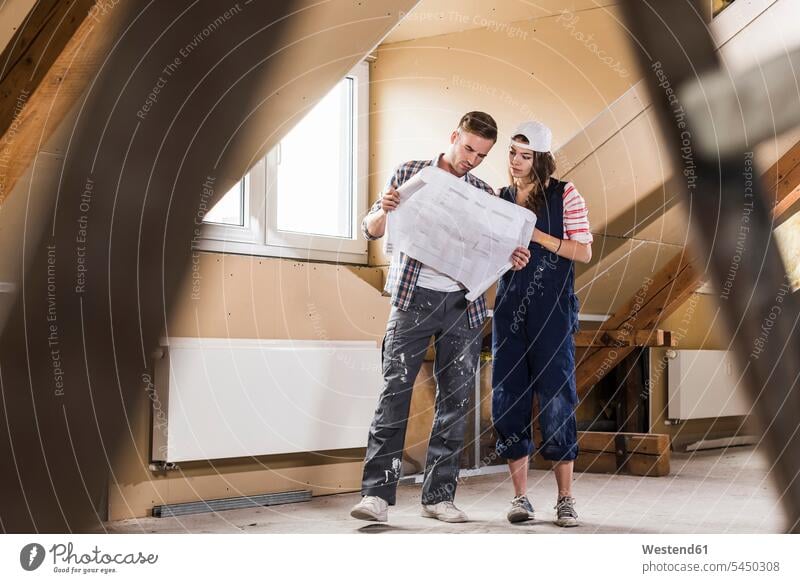 Young couple on construction site of their new home, looking at construction plan floor plan floor plans ground plan ground plans DIY Doityourself
