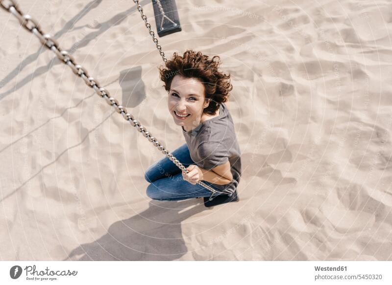 Happy woman on a swing females women beach beaches smiling smile swing set playground swing swingset Adults grown-ups grownups adult people persons human being